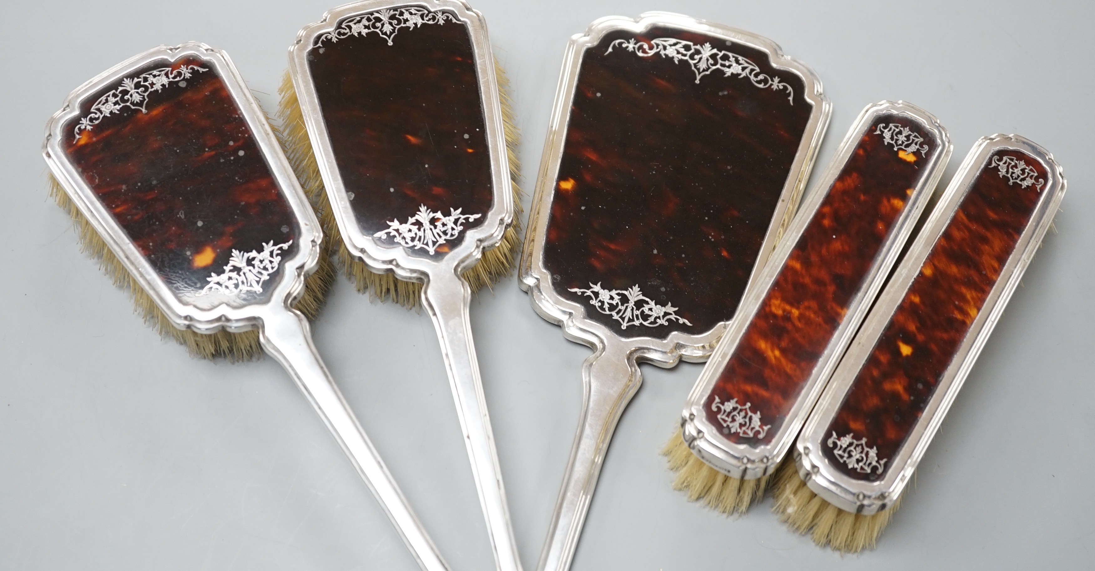 A George V silver and tortoiseshell mounted five piece mirror and brush set by Mappin & Webb, London, 1932/3.